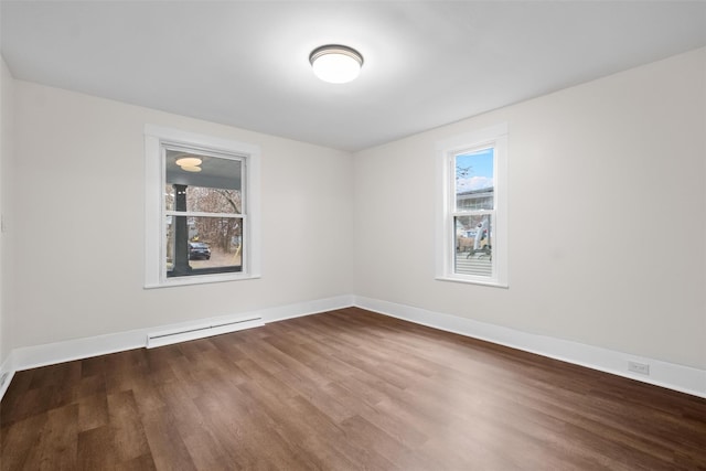 empty room with hardwood / wood-style floors and a baseboard radiator