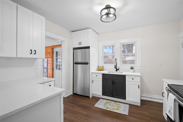 kitchen featuring backsplash, white cabinets, sink, dark hardwood / wood-style floors, and stainless steel fridge