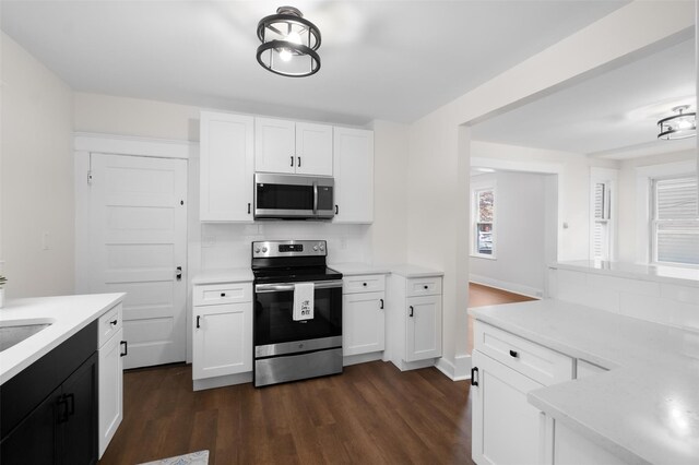 kitchen featuring tasteful backsplash, white cabinetry, dark hardwood / wood-style flooring, and stainless steel appliances