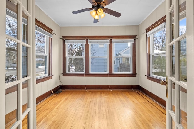 unfurnished sunroom featuring ceiling fan