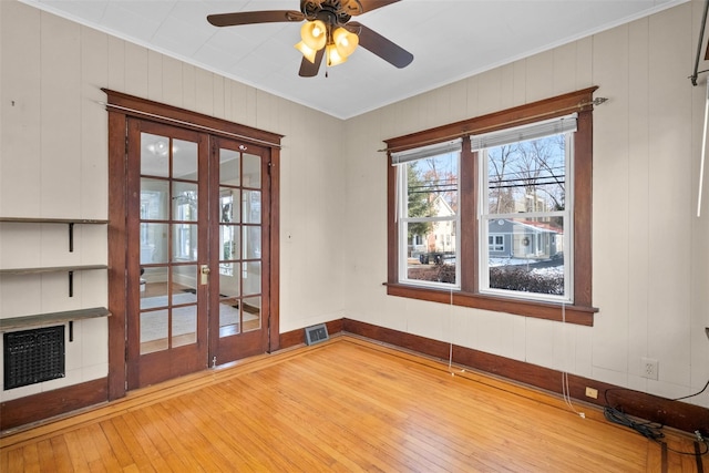 spare room featuring french doors, light hardwood / wood-style flooring, ceiling fan, and ornamental molding