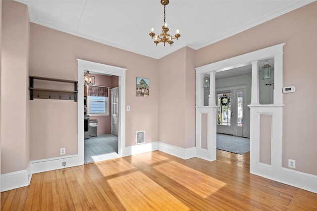 spare room featuring french doors, an inviting chandelier, and hardwood / wood-style flooring