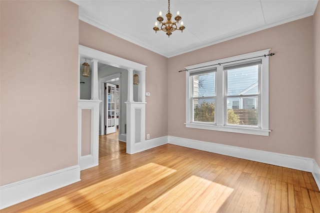 spare room with a chandelier, hardwood / wood-style flooring, and ornamental molding