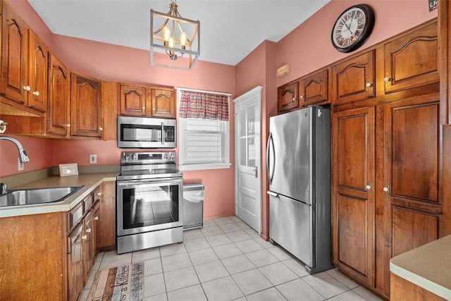 kitchen with sink, hanging light fixtures, stainless steel appliances, an inviting chandelier, and light tile patterned flooring