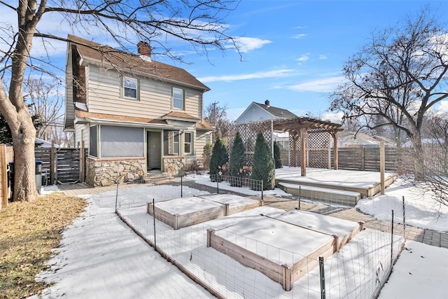 snow covered rear of property with a pergola and a deck