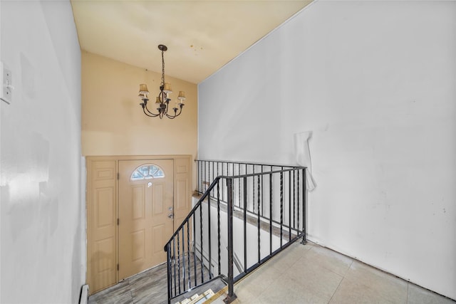 stairs featuring a baseboard radiator and an inviting chandelier