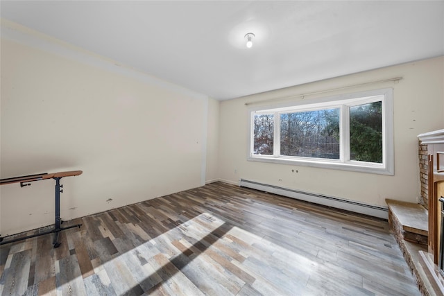 spare room with hardwood / wood-style flooring and a baseboard heating unit