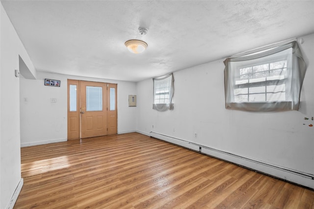 entrance foyer featuring a baseboard heating unit, a textured ceiling, and light hardwood / wood-style flooring