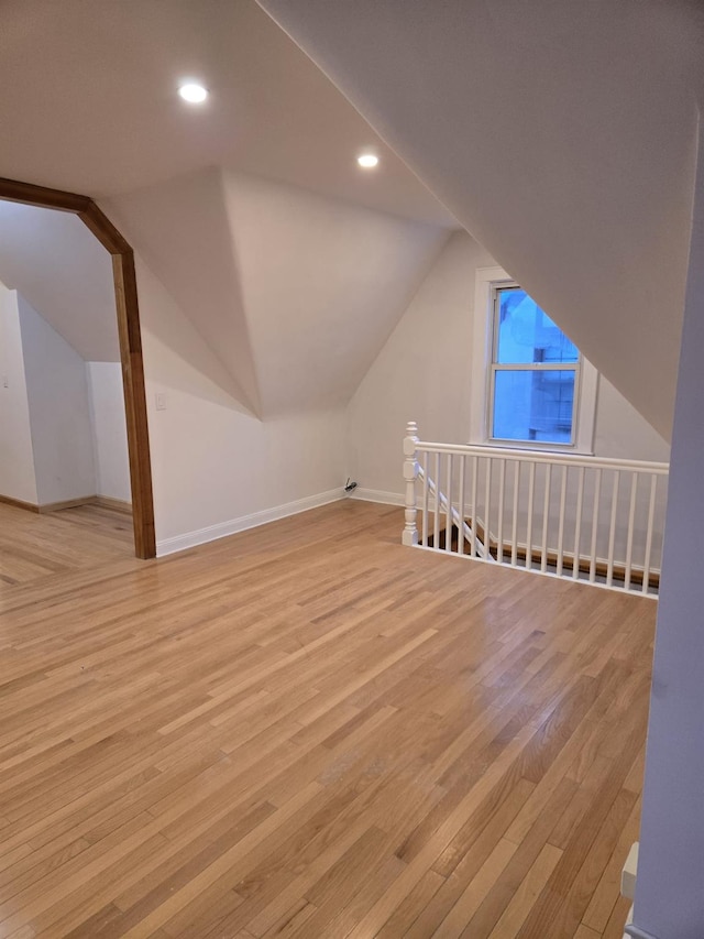 additional living space featuring light hardwood / wood-style flooring and lofted ceiling