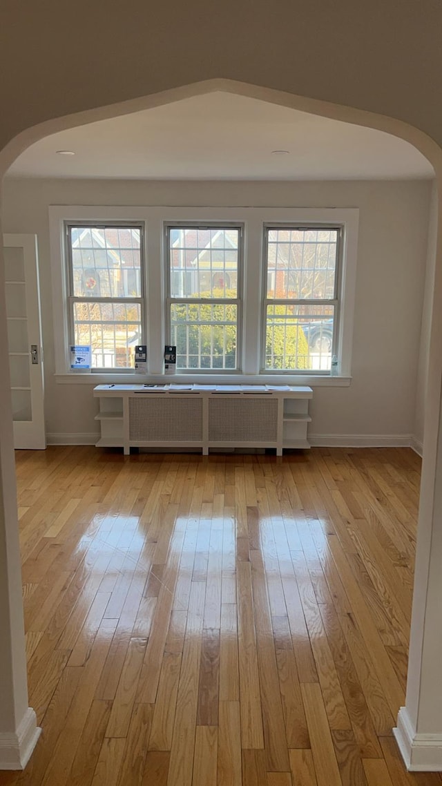 spare room with radiator and light wood-type flooring