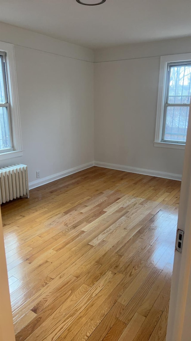 spare room with radiator and light hardwood / wood-style floors