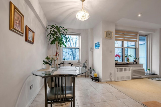 carpeted dining room with a notable chandelier and radiator