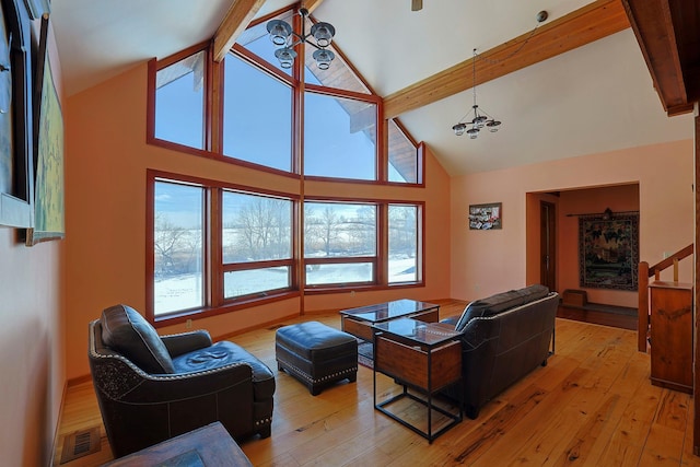 living room with a notable chandelier, high vaulted ceiling, light hardwood / wood-style floors, and beamed ceiling