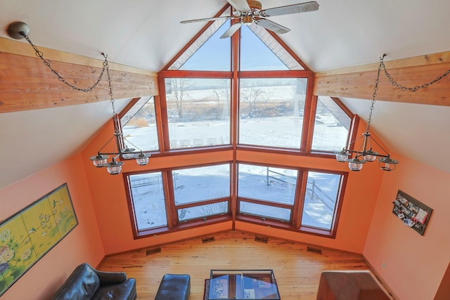 unfurnished living room with ceiling fan with notable chandelier, vaulted ceiling, and wood-type flooring