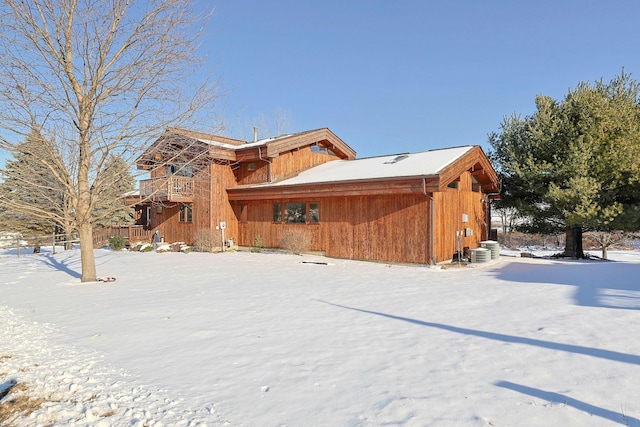 snow covered property with central AC unit