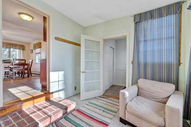 living area featuring light tile patterned flooring and french doors