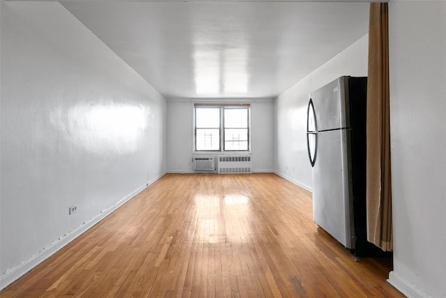 spare room with radiator heating unit and hardwood / wood-style flooring