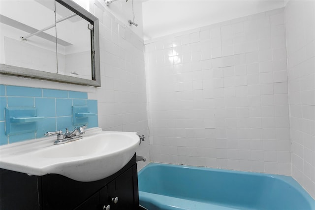 bathroom with tasteful backsplash, tile walls, vanity, and shower / bathtub combination