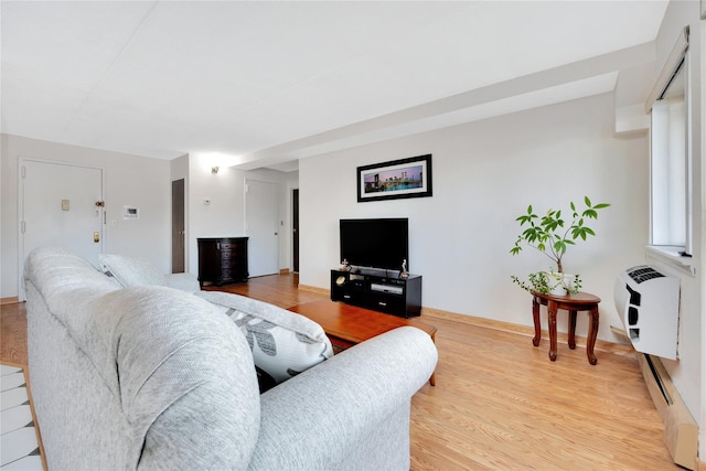 living room with heating unit, light hardwood / wood-style floors, and a baseboard heating unit