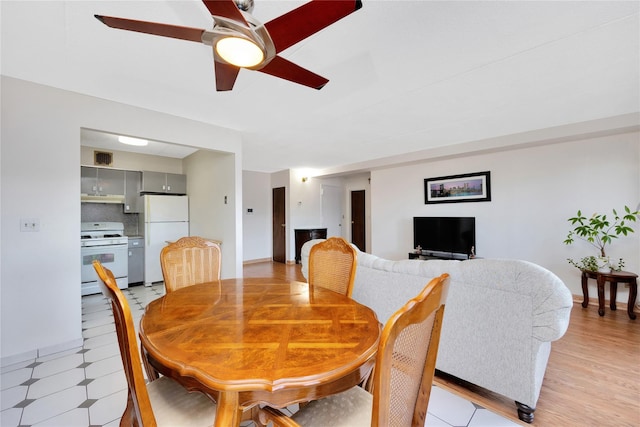 dining space with light hardwood / wood-style flooring and ceiling fan