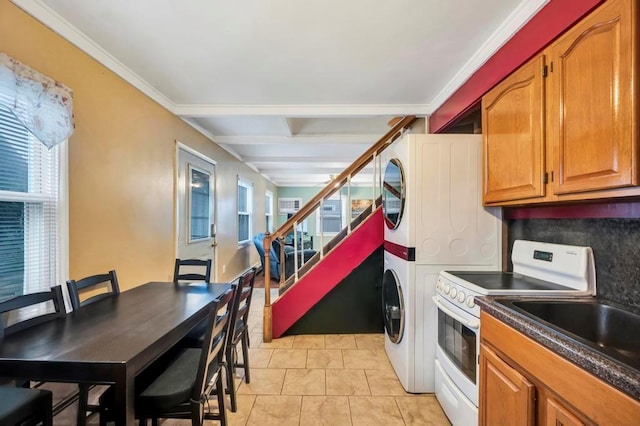 kitchen featuring tasteful backsplash, white range with electric stovetop, crown molding, stacked washer and dryer, and light tile patterned flooring