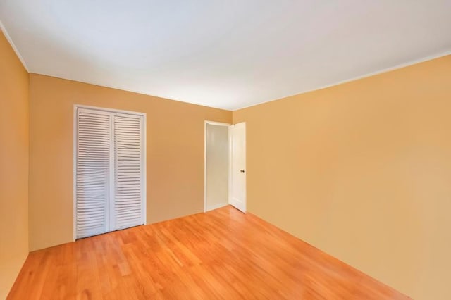 unfurnished bedroom with hardwood / wood-style floors and a closet