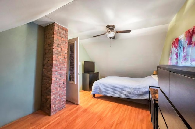 bedroom featuring ceiling fan, light hardwood / wood-style floors, and lofted ceiling