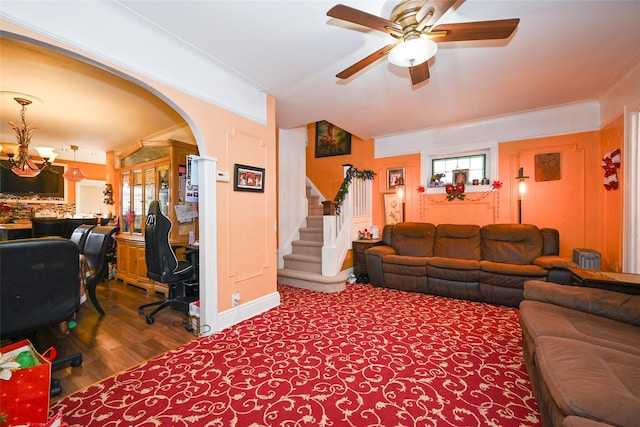 living room featuring wood-type flooring and ceiling fan with notable chandelier