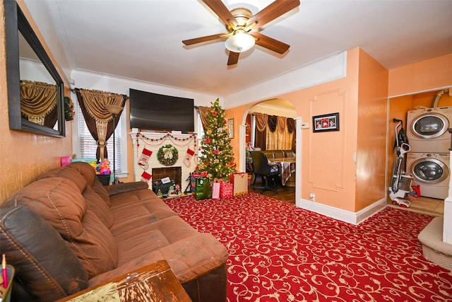 living room with ceiling fan and stacked washer and dryer