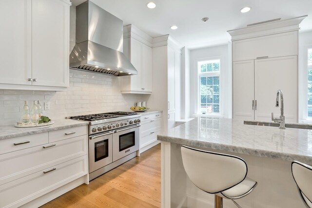 2 Weaver St Unit 3, Scarsdale, NY 10583 - kitchen featuring white cabinetry, double oven range, wall chimney range hood, and light hardwood / wood-style floors