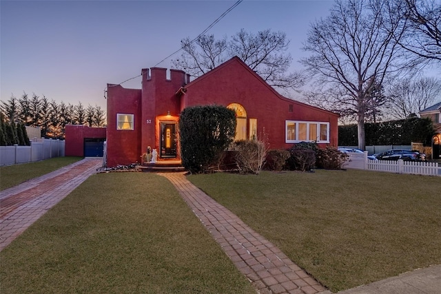 view of front facade with a yard and a garage