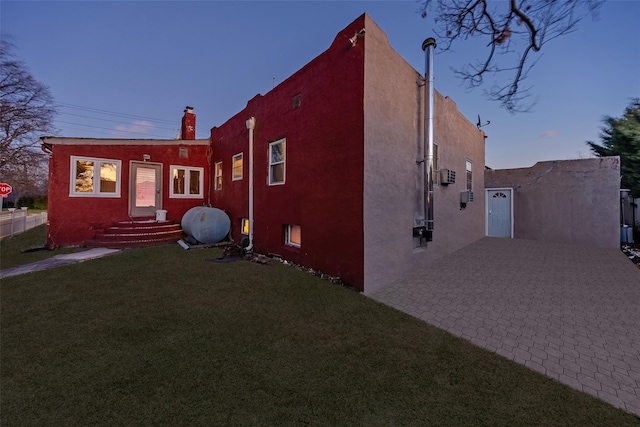 property exterior at dusk with a lawn