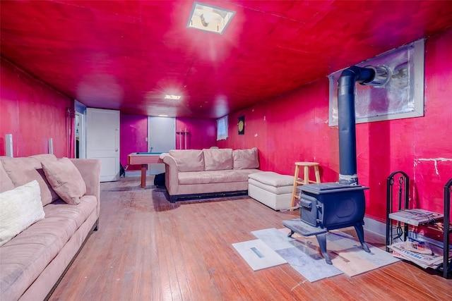 living room with a wood stove and light hardwood / wood-style flooring