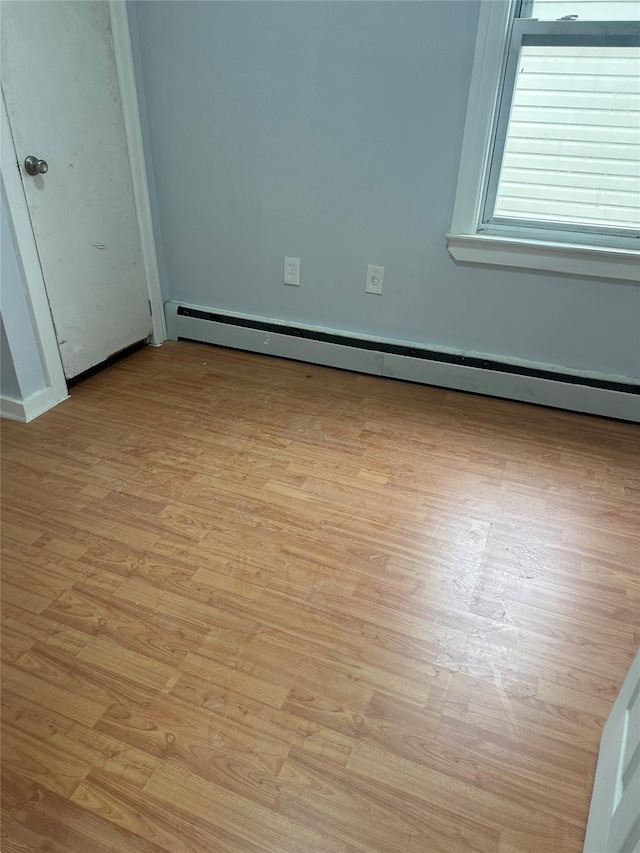 unfurnished bedroom with baseboard heating and light hardwood / wood-style flooring