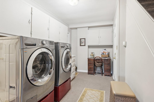 clothes washing area featuring cabinets, ornamental molding, and washing machine and clothes dryer