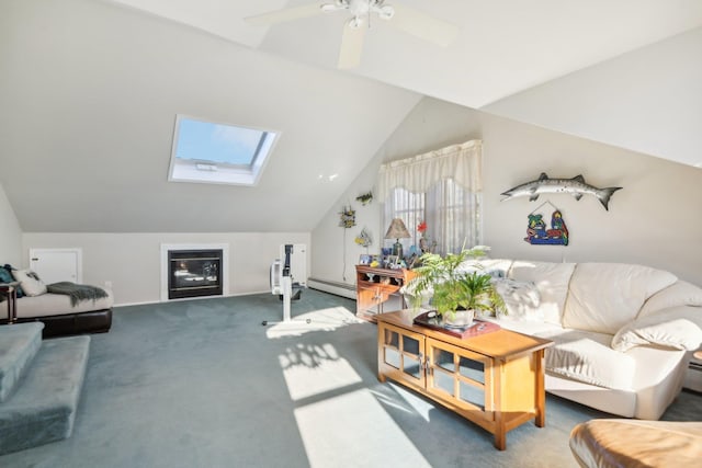 living room with ceiling fan, vaulted ceiling with skylight, carpet, and a baseboard heating unit