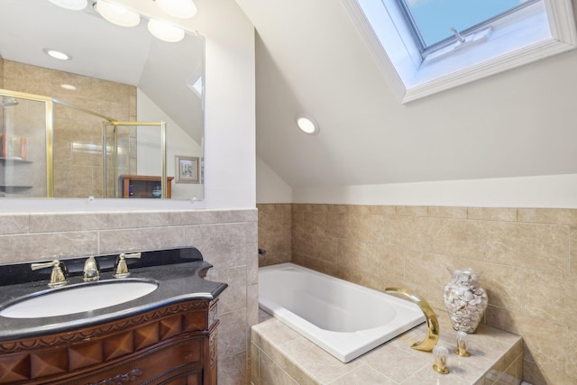 bathroom featuring vaulted ceiling with skylight, vanity, and independent shower and bath