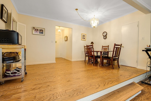 dining space featuring crown molding, light hardwood / wood-style flooring, and a chandelier