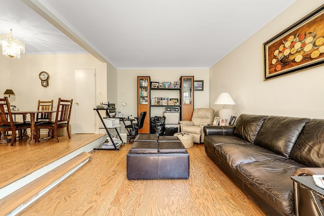 living room with hardwood / wood-style floors, an inviting chandelier, and crown molding