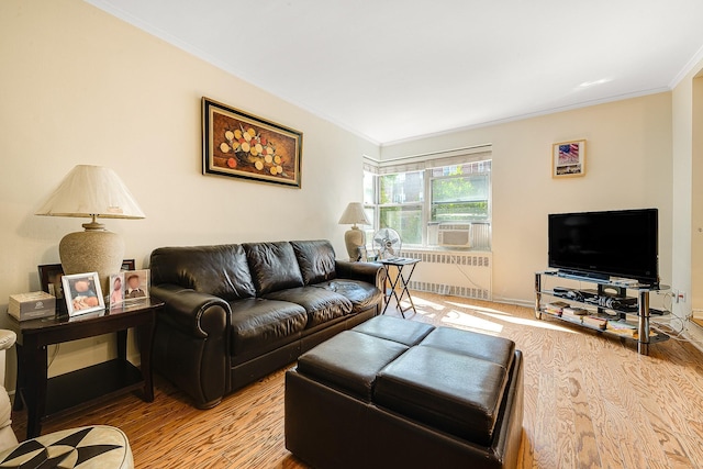 living room featuring cooling unit, hardwood / wood-style flooring, radiator, and ornamental molding