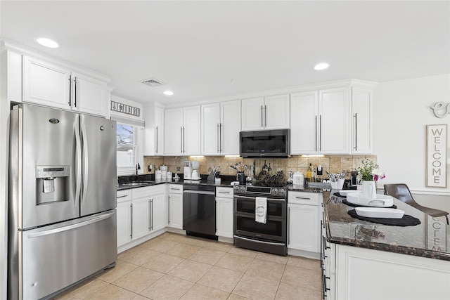 kitchen with white cabinetry, sink, dark stone countertops, light tile patterned flooring, and appliances with stainless steel finishes