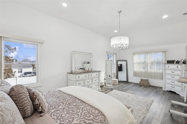 bedroom with a baseboard heating unit, an inviting chandelier, and dark wood-type flooring