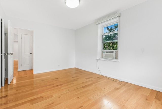 spare room with cooling unit and hardwood / wood-style floors