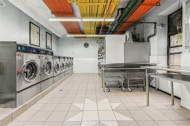 laundry area featuring light tile patterned floors and washing machine and clothes dryer