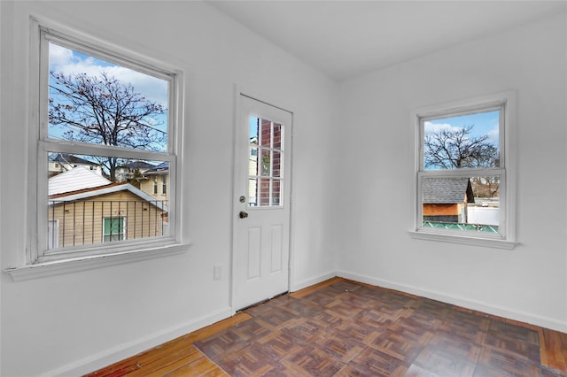 entryway featuring plenty of natural light and dark parquet flooring