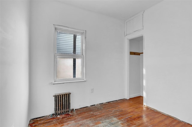 unfurnished room featuring radiator heating unit and light wood-type flooring