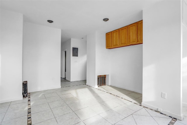 spare room featuring electric panel and light tile patterned floors