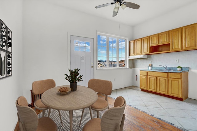 tiled dining area featuring ceiling fan and sink