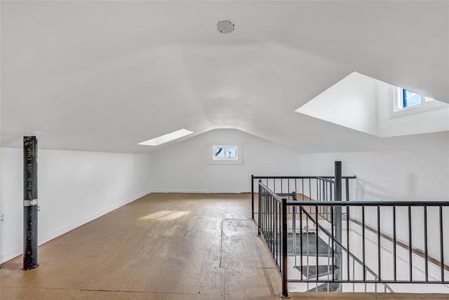 additional living space featuring lofted ceiling with skylight and plenty of natural light