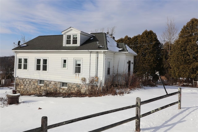 snow covered property featuring fence